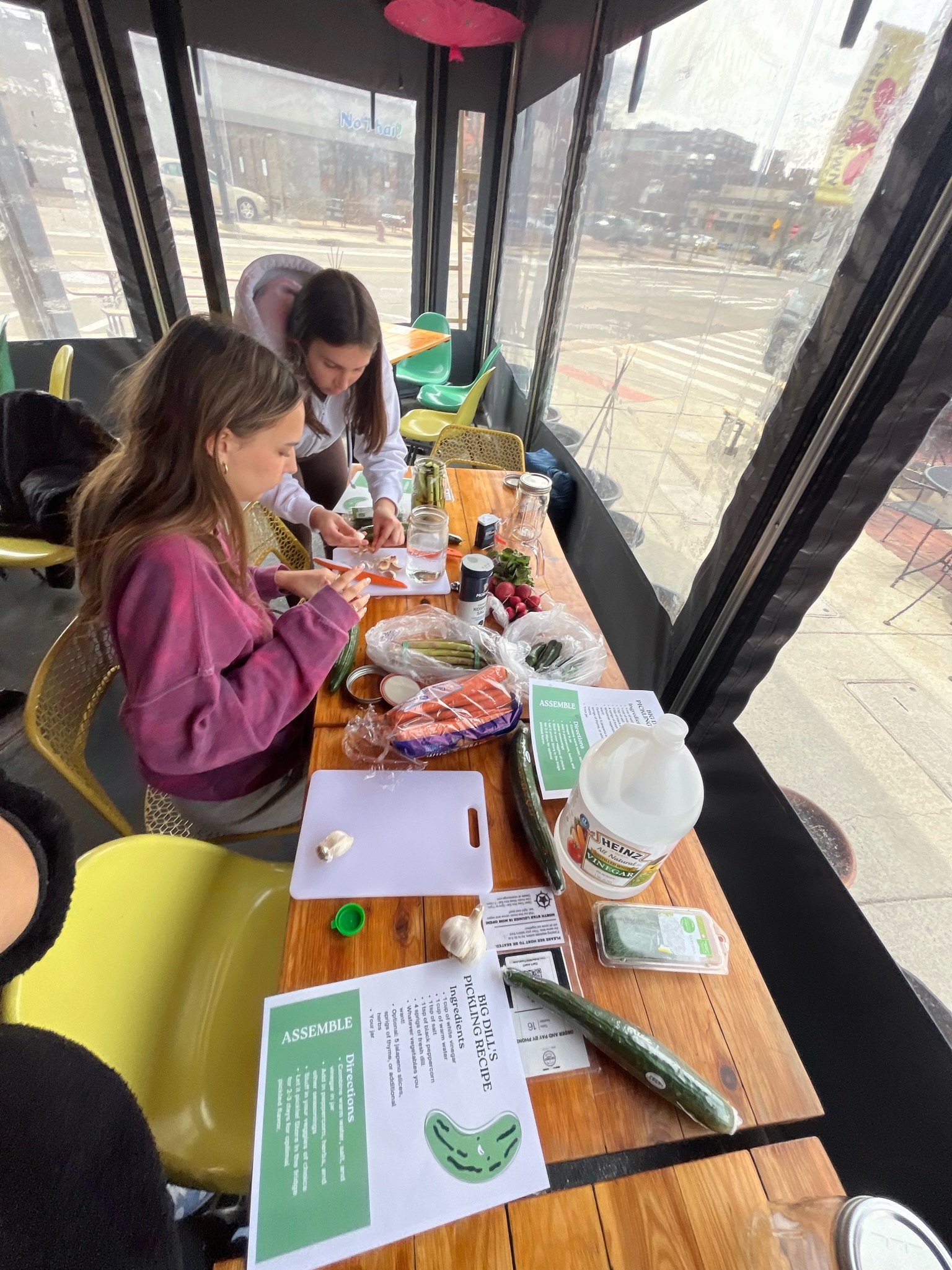 Two girls cutting and pickling vegetables