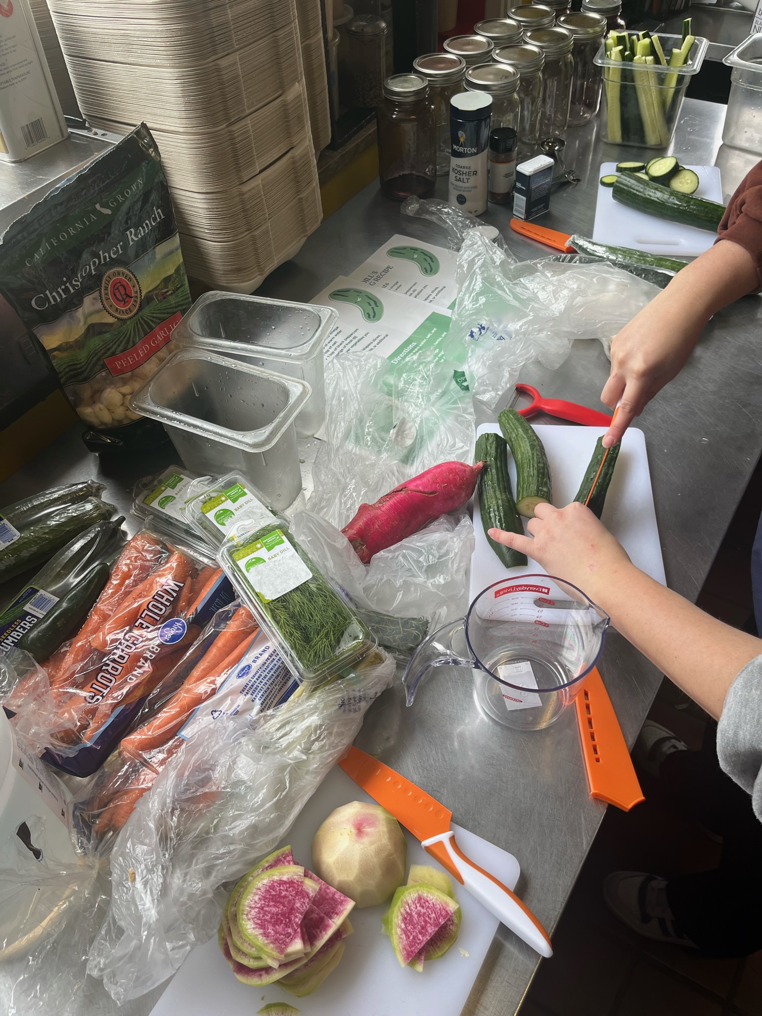 Ingredients used to pickle, including cucumbers, herbs, and spices